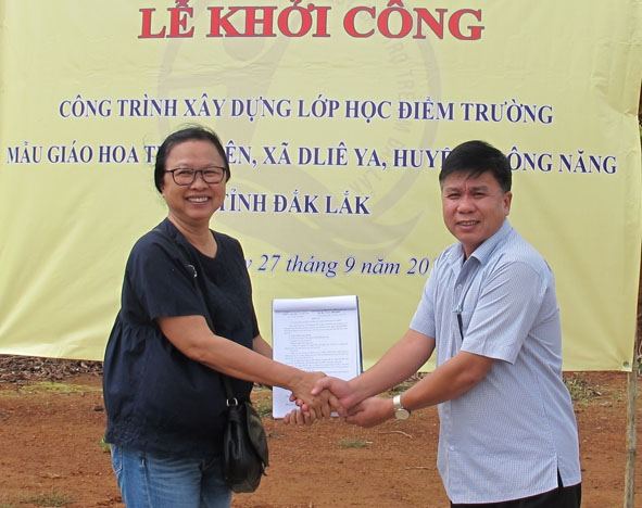Điều phối viên của Tổ chức Children Action trao Quyết định tài trợ xây dựng điểm trường thôn Ea Bi  cho ông Lâm Đình Nhiên, Giám đốc Quỹ Bảo trợ trẻ em tỉnh. 